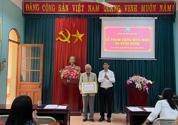  Đồng chí Vy Minh Long - Ủy viên Ban Thường vụ Huyện ủy, Trưởng Ban tuyên giáo, giám đốc trung tâm Chính trị huyện Cao Lộc trao tặng Huy hiệu 55 năm tuổi Đảng cho đồng chí Hoàng Minh Kai.