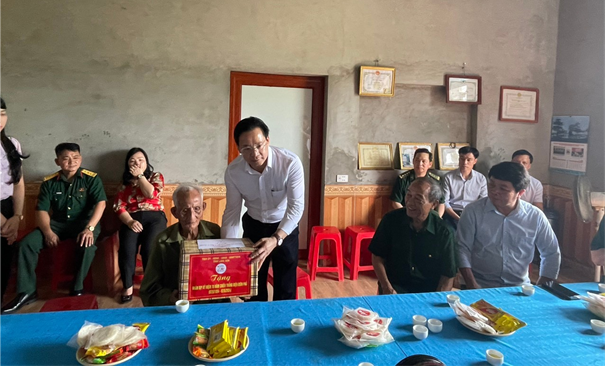 Đồng chí  Hoàng Văn Nghiệm, Phó Bí thư Thường trực Tỉnh uỷ, Trưởng đoàn Đại biểu Quốc hội tỉnh tặng quà cho ông Hoàng Chắn Phùng chiến sĩ Điện Biên.