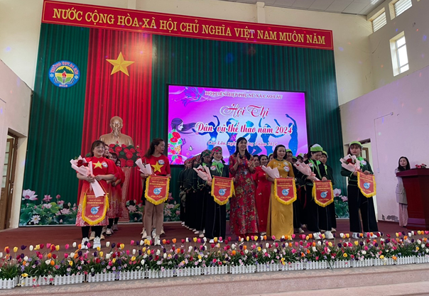 Đồng chí Lộc Thị Vàng – Chủ tịch Hội LHPN xã tặng hoa và cờ lưu niệm cho các đội tham gia hội thi dân vũ thể thao năm 2024.