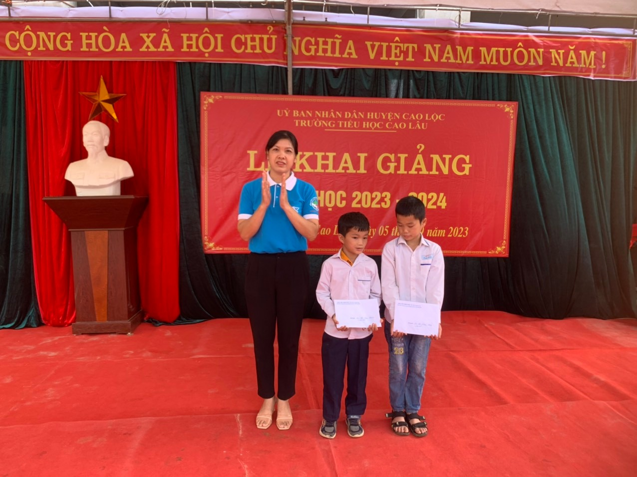 Bà Lộc Thị Vàng – Chủ tịch Hội Phụ nữ xã trao quà mô hình “ Mẹ đỡ đầu”  cho các em có hoàn cảnh khó khăn.